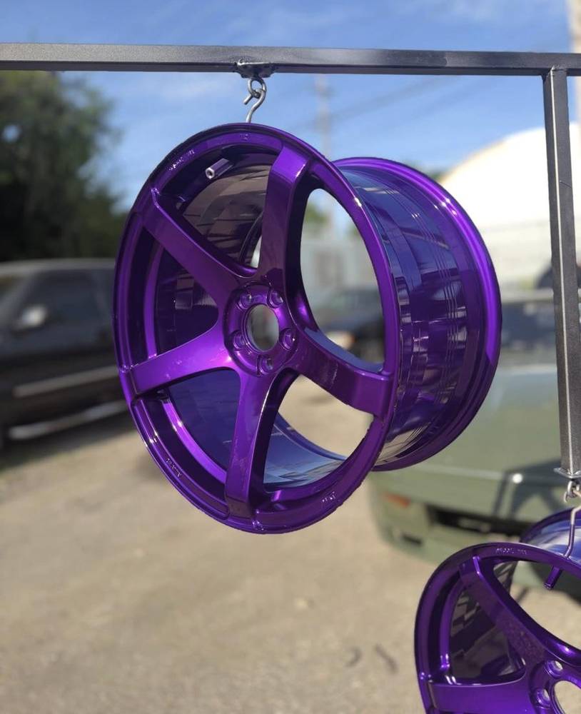 Wheel coated in candy purple hanging on the curing rack
